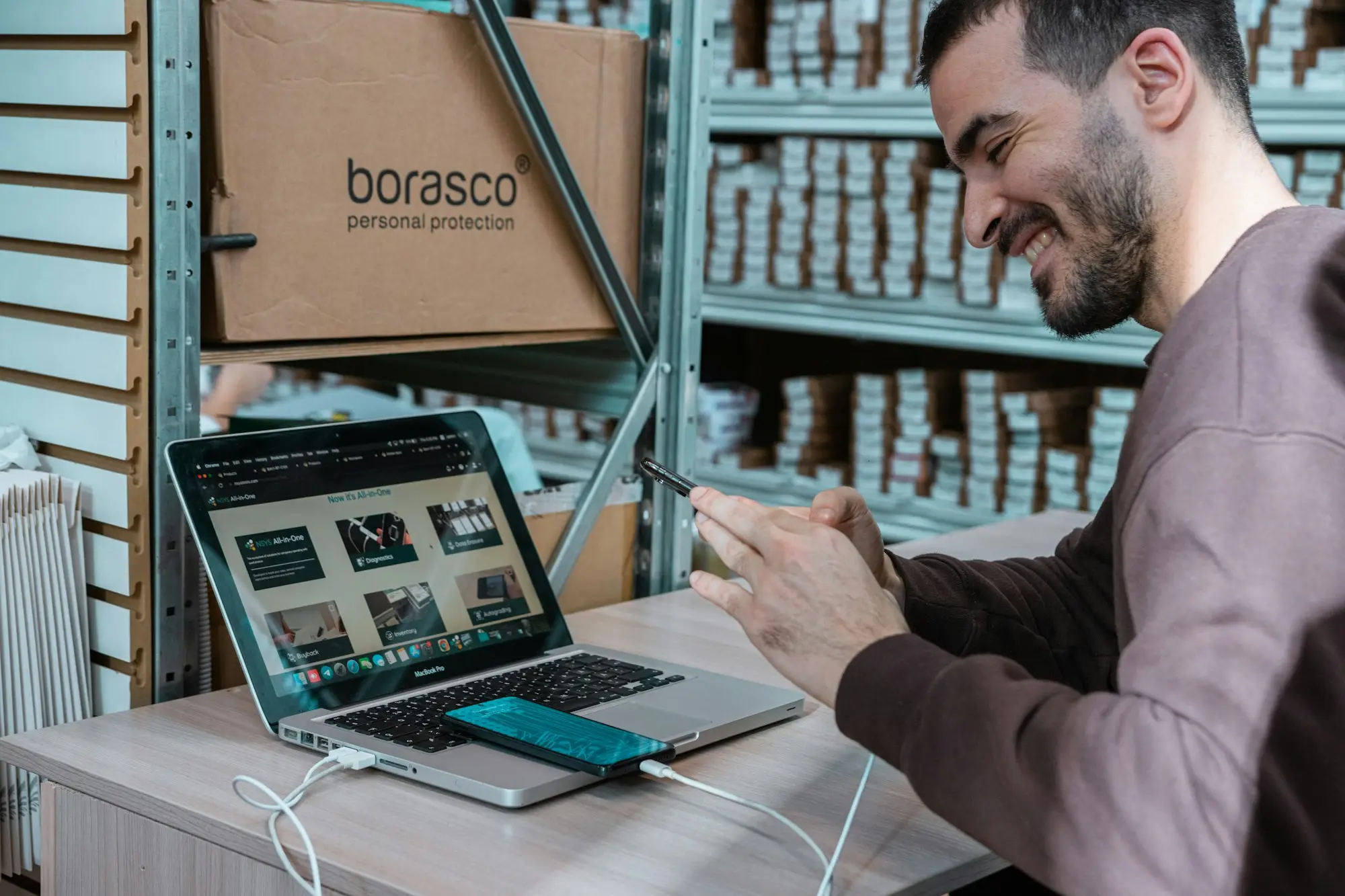 Business owner on a phone call while packing stock in the warehouse
