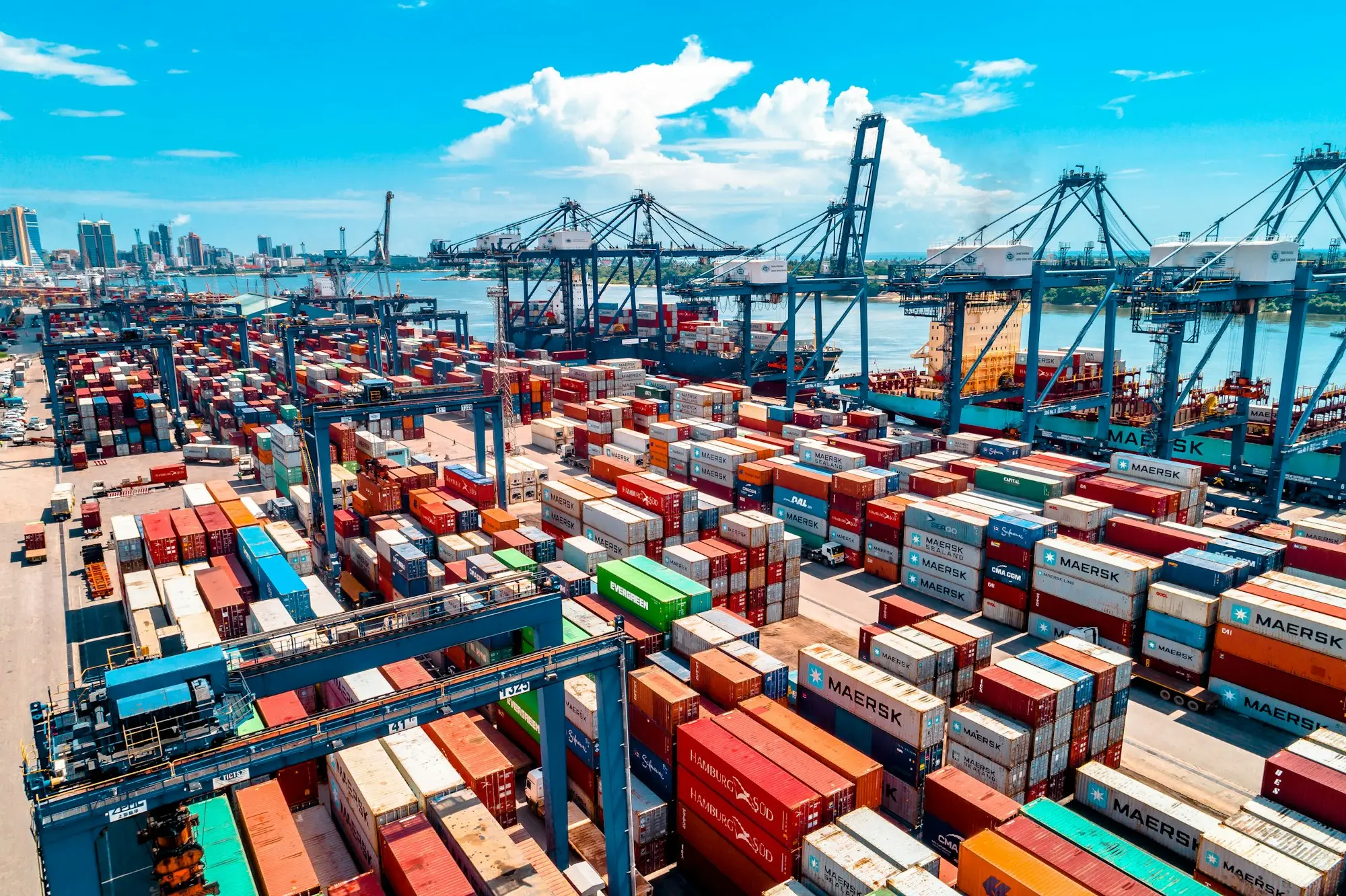 Container ship berthed at a busy port with cranes