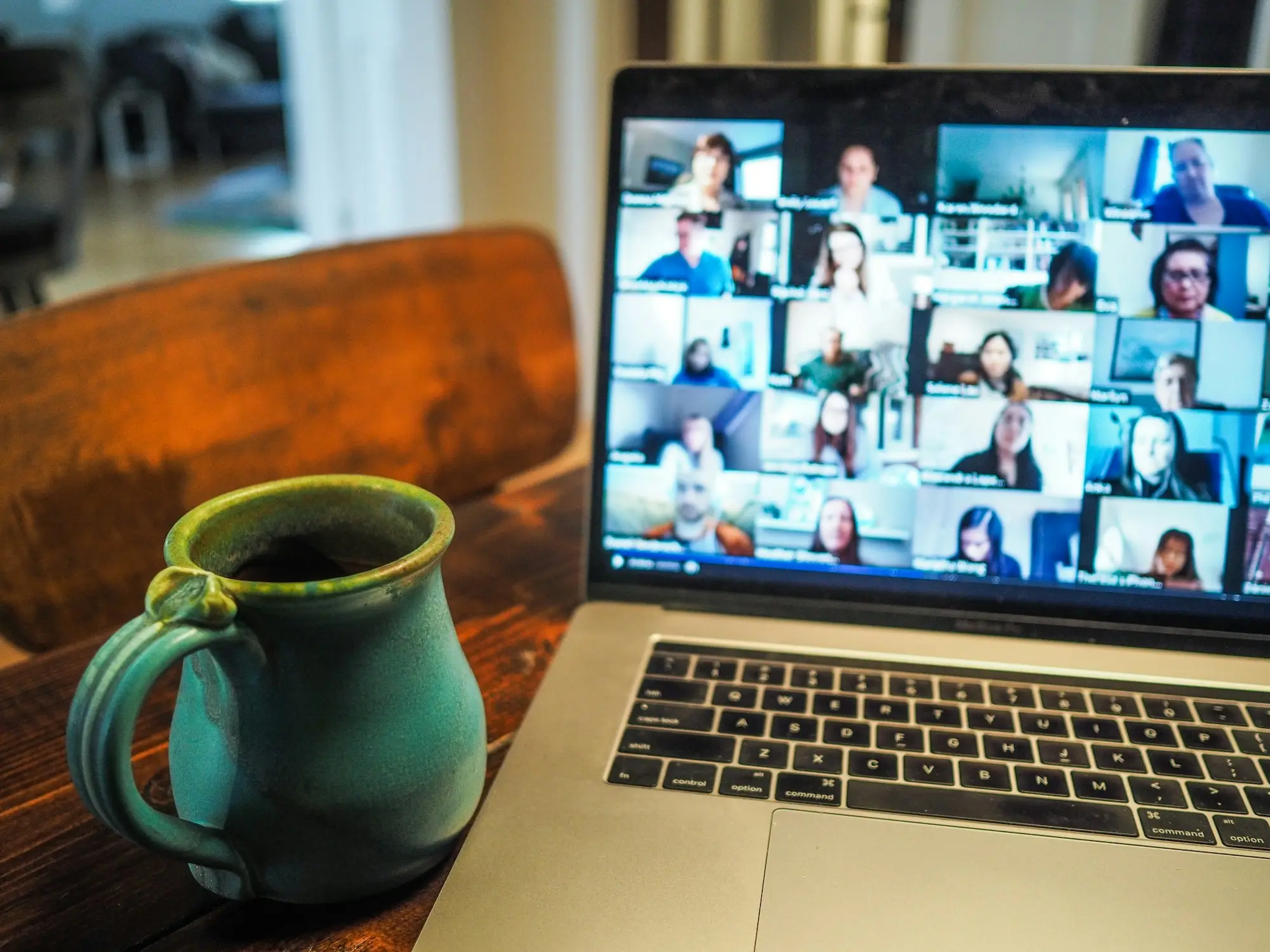 Video call with an overseas supplier on a laptop beside a mug